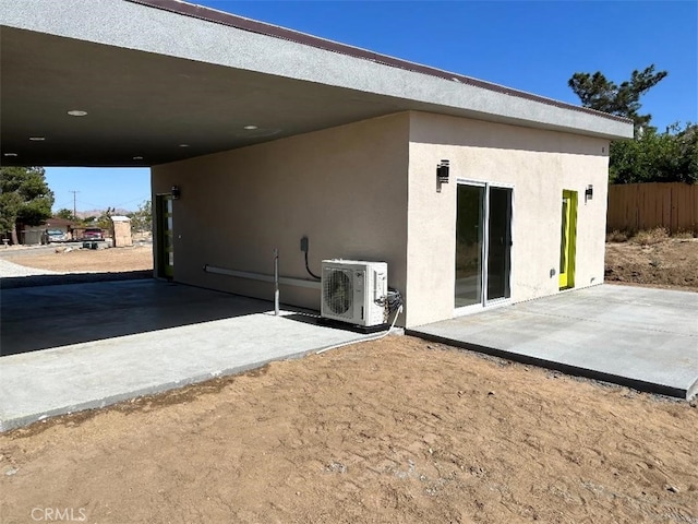 back of property with ac unit and a patio