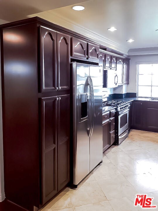 kitchen with dark brown cabinets, ornamental molding, and appliances with stainless steel finishes