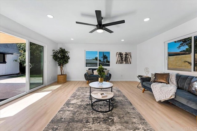 living room with light hardwood / wood-style floors and ceiling fan