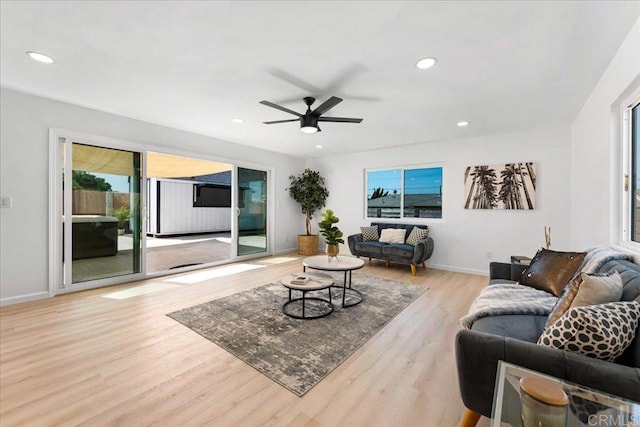 living room featuring a healthy amount of sunlight, light wood-type flooring, and ceiling fan