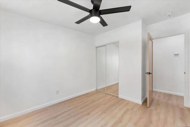 unfurnished bedroom featuring a closet, light wood-type flooring, and ceiling fan