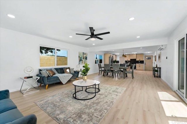 living room with ceiling fan and light hardwood / wood-style flooring