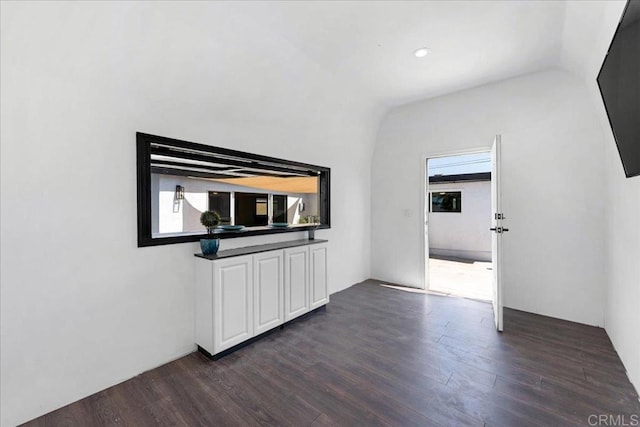 interior space with dark hardwood / wood-style floors and vaulted ceiling