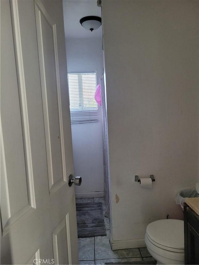 bathroom featuring toilet, vanity, and tile patterned flooring