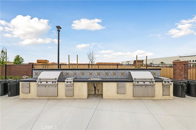 view of patio with an outdoor kitchen and a grill