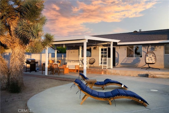 back house at dusk with a patio area