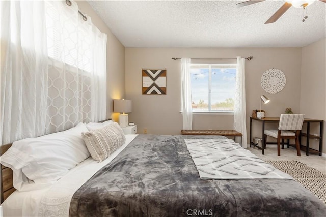 carpeted bedroom featuring ceiling fan and a textured ceiling