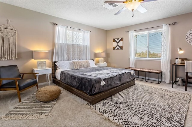 carpeted bedroom featuring ceiling fan, multiple windows, and a textured ceiling