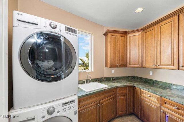 washroom with stacked washer / dryer, sink, and cabinets