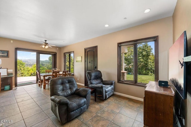 living room with tile patterned floors, a wealth of natural light, and ceiling fan