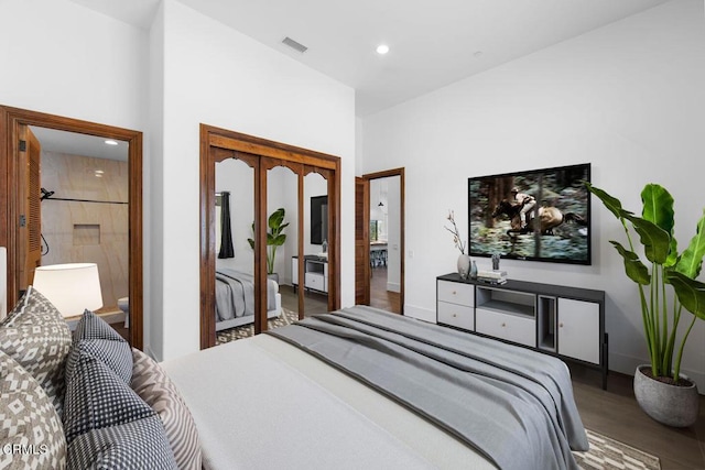 bedroom featuring hardwood / wood-style flooring, connected bathroom, and a closet