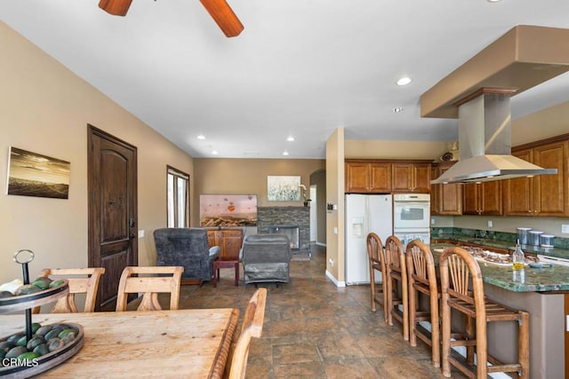 dining area featuring a fireplace and ceiling fan