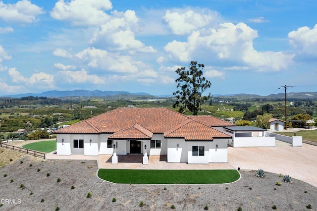 view of front of property with a mountain view and a front yard