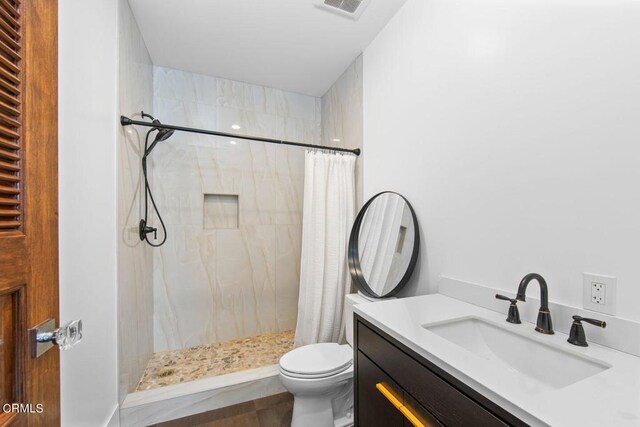 bathroom with toilet, vanity, and a shower with shower curtain