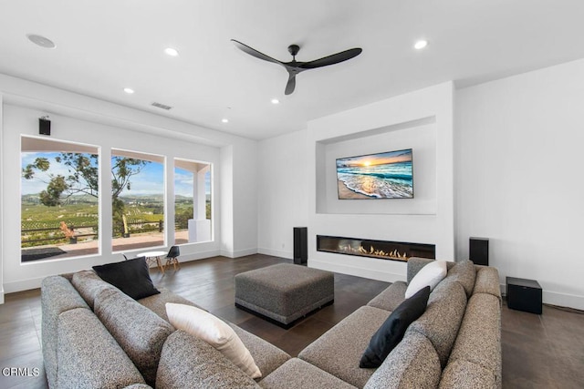 living room featuring ceiling fan and dark wood-type flooring