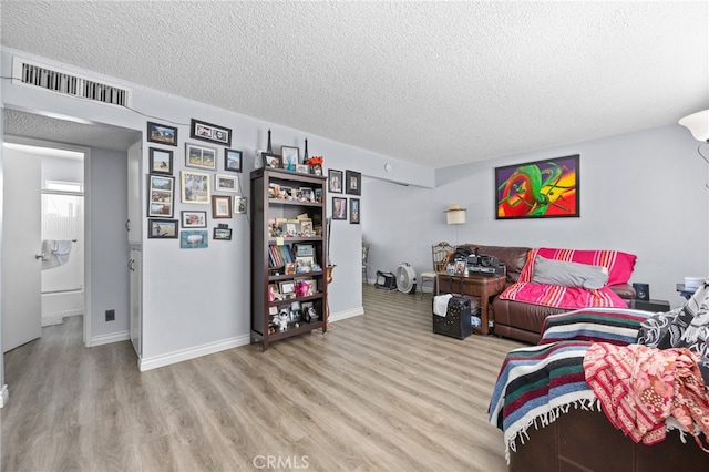 living room with a textured ceiling and light hardwood / wood-style flooring