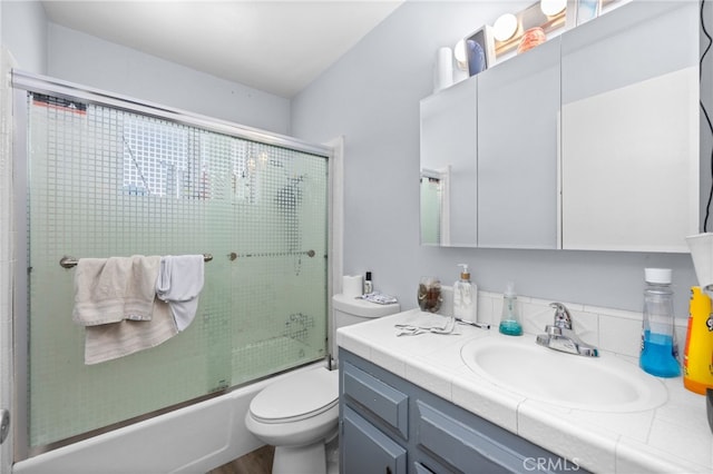 full bathroom with toilet, vanity, and combined bath / shower with glass door