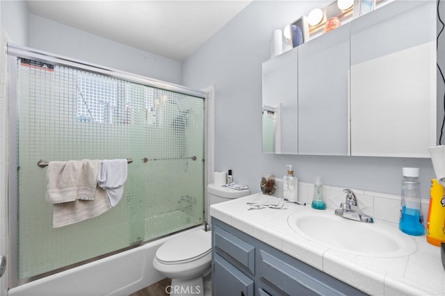 full bathroom featuring toilet, enclosed tub / shower combo, and vanity