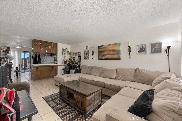 living room featuring light tile patterned floors, a textured ceiling, and ceiling fan