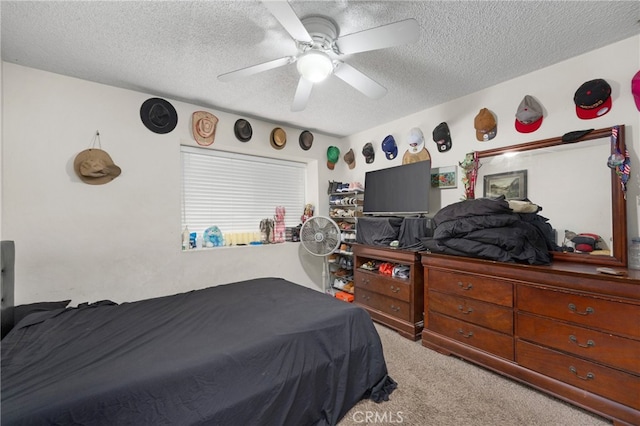 bedroom with ceiling fan, a textured ceiling, and light carpet