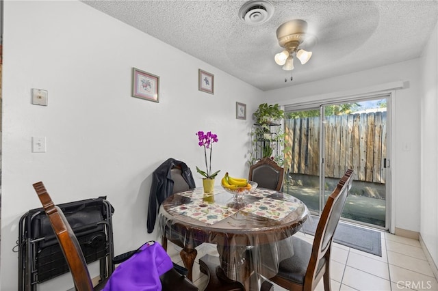 tiled dining area featuring ceiling fan and a textured ceiling