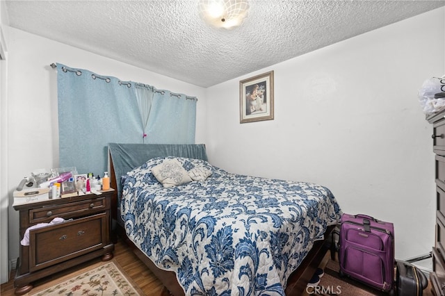 bedroom with wood-type flooring and a textured ceiling