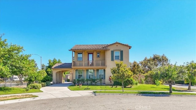 mediterranean / spanish-style house with a balcony, a front lawn, and a carport