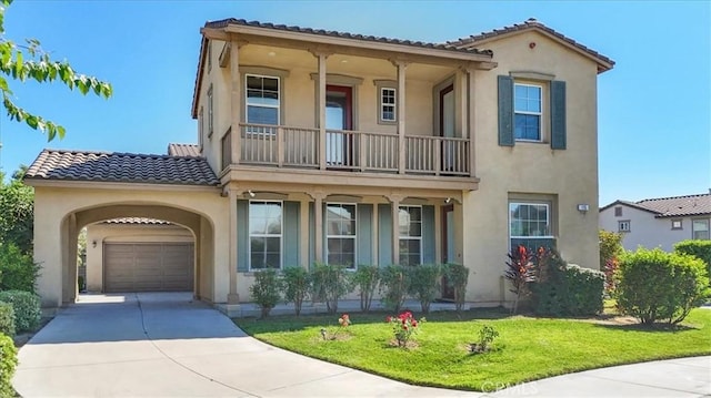 mediterranean / spanish home with a garage, a balcony, and a front lawn