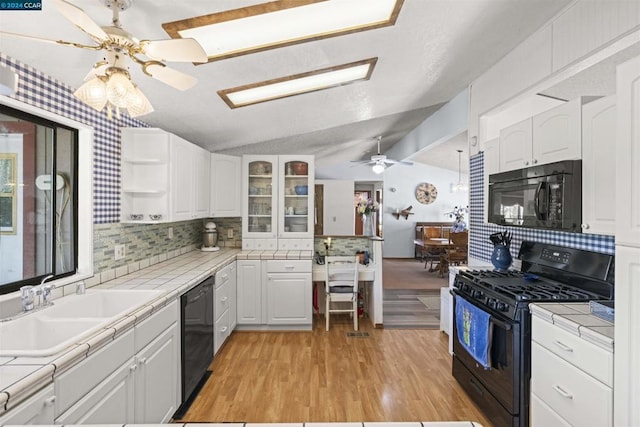 kitchen with white cabinetry, tile counters, and black appliances