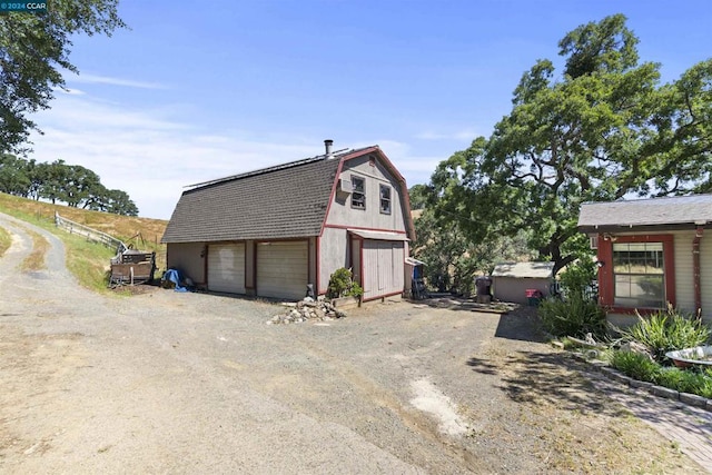 view of side of home featuring a garage and an outdoor structure