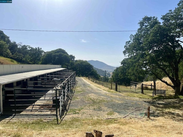 view of yard featuring a mountain view, a rural view, and an outdoor structure