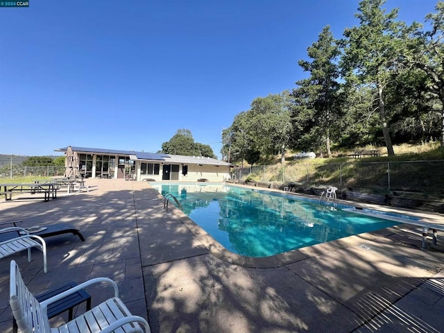 view of pool featuring a diving board and a patio area