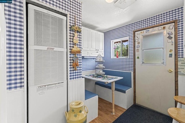 kitchen with white cabinetry, light hardwood / wood-style flooring, and a textured ceiling