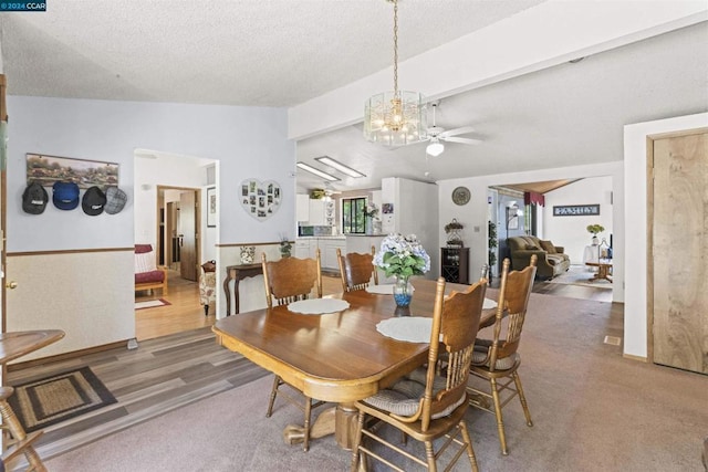 dining room with a chandelier, a textured ceiling, and vaulted ceiling with beams