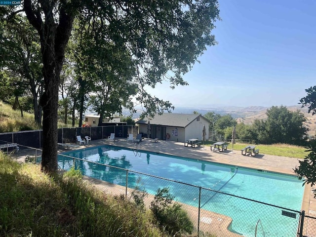 view of swimming pool with a mountain view and a patio