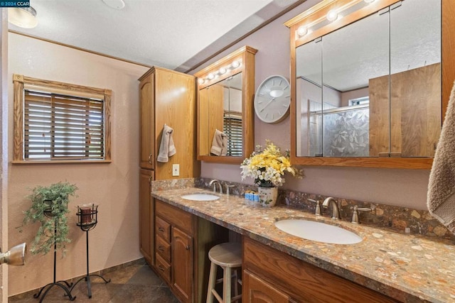 bathroom with tile patterned flooring, vanity, a wealth of natural light, and a shower with shower door