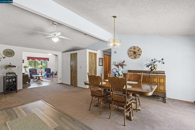 carpeted dining space with ceiling fan with notable chandelier, lofted ceiling with beams, and a textured ceiling