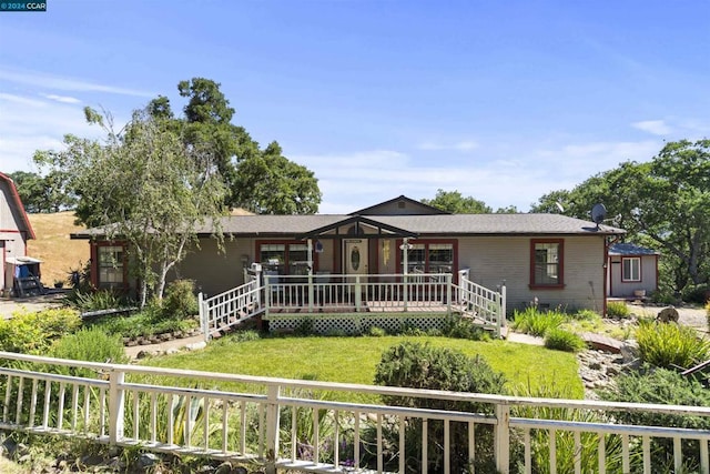 ranch-style home with a wooden deck and a front lawn