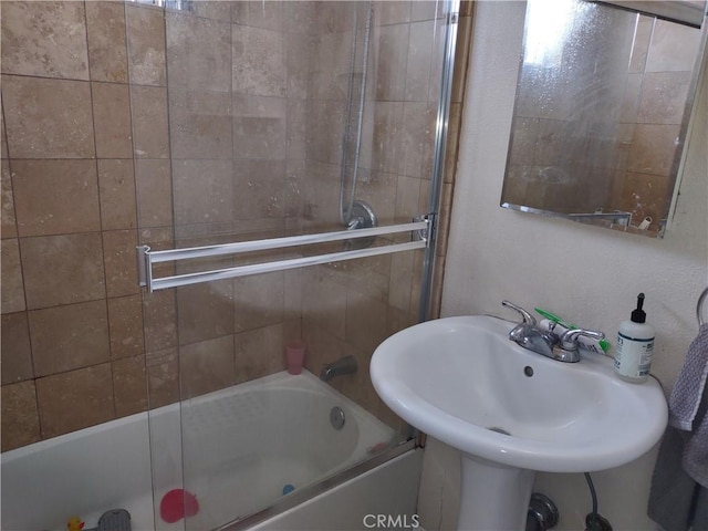 bathroom featuring tiled shower / bath combo and sink