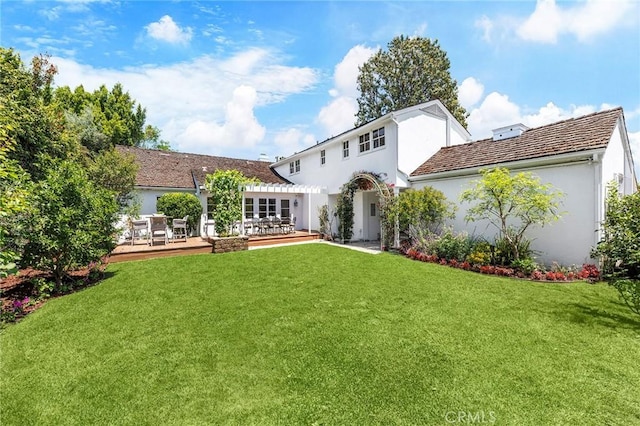 back of house with a lawn and a wooden deck