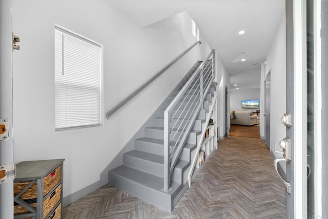 stairway with a wealth of natural light and parquet floors