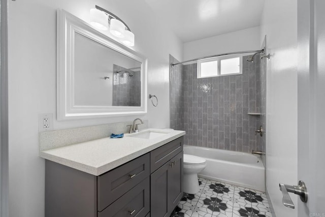 full bathroom featuring vanity, tiled shower / bath combo, and toilet