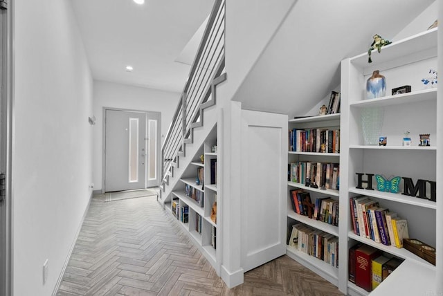 hall with lofted ceiling and parquet floors