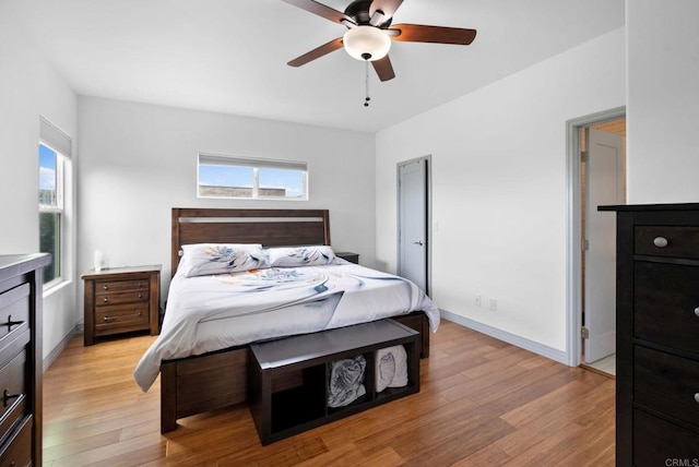 bedroom featuring light wood-type flooring, multiple windows, and ceiling fan