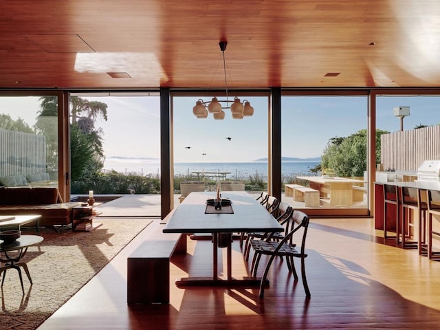 sunroom / solarium featuring a water view and wood ceiling