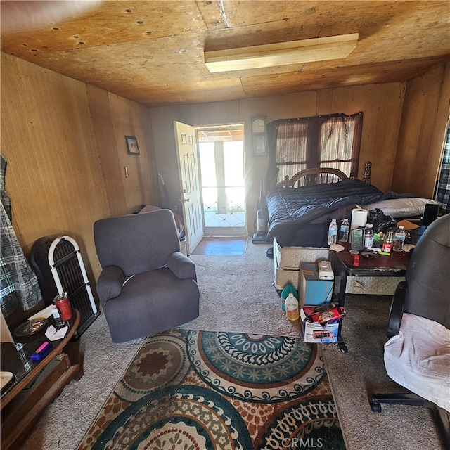 carpeted bedroom with wood ceiling, wooden walls, and access to exterior