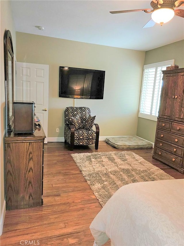 bedroom with ceiling fan and dark hardwood / wood-style flooring