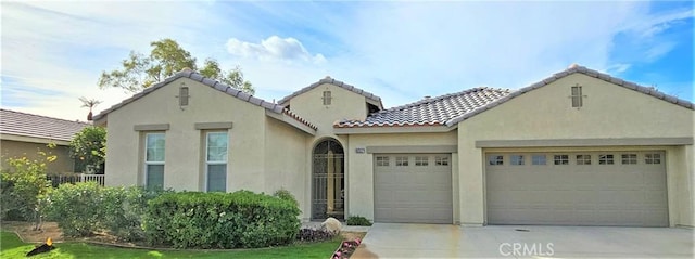 mediterranean / spanish house featuring a garage and a front lawn