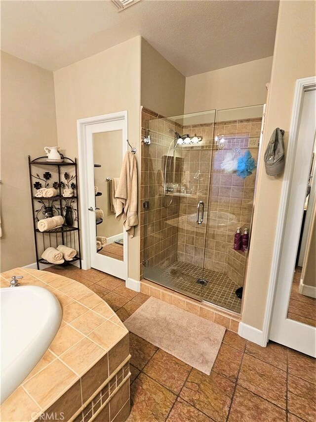 bathroom with tile patterned floors and independent shower and bath