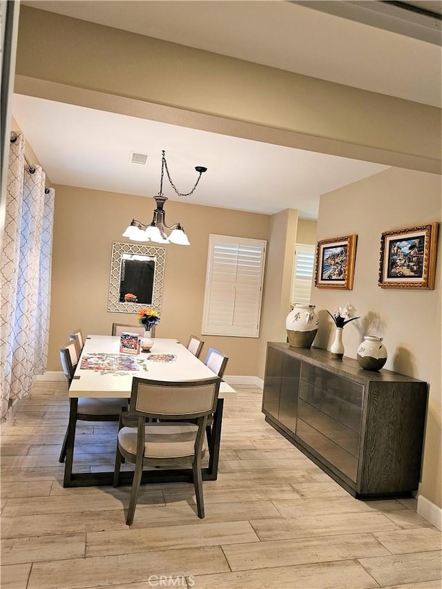 dining space featuring light wood-type flooring and a chandelier